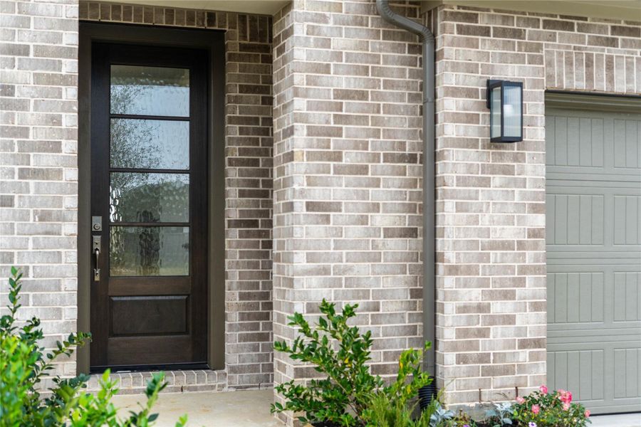 As you walk up to this beautiful home, you notice the brick elevation with contemporary black wall sconce light fixture. The inviting front door is accentuated by gorgeous obscure glass panels and handle set contributing to the strong curb appeal.