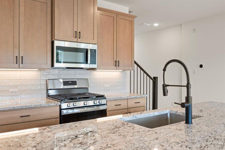 Gorgeous cabinetry, designer backsplash and beautiful countertops paired with contemporary stainless steel blend together to create this dream kitchen! Gorgeous cabinetry, designer backsplash and beautiful countertops paired with contemporary stainless steel blend together to create this dream kitchen!