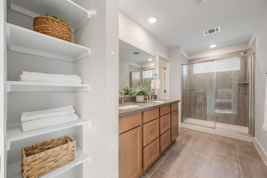 Bathroom attached to the primary bedroom. Double sink, custom shelves and walk-in shower.