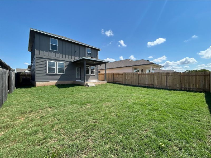 Rear view of house featuring a fenced backyard and board and batten siding Rear view of house featuring a fenced backyard and board and batten siding