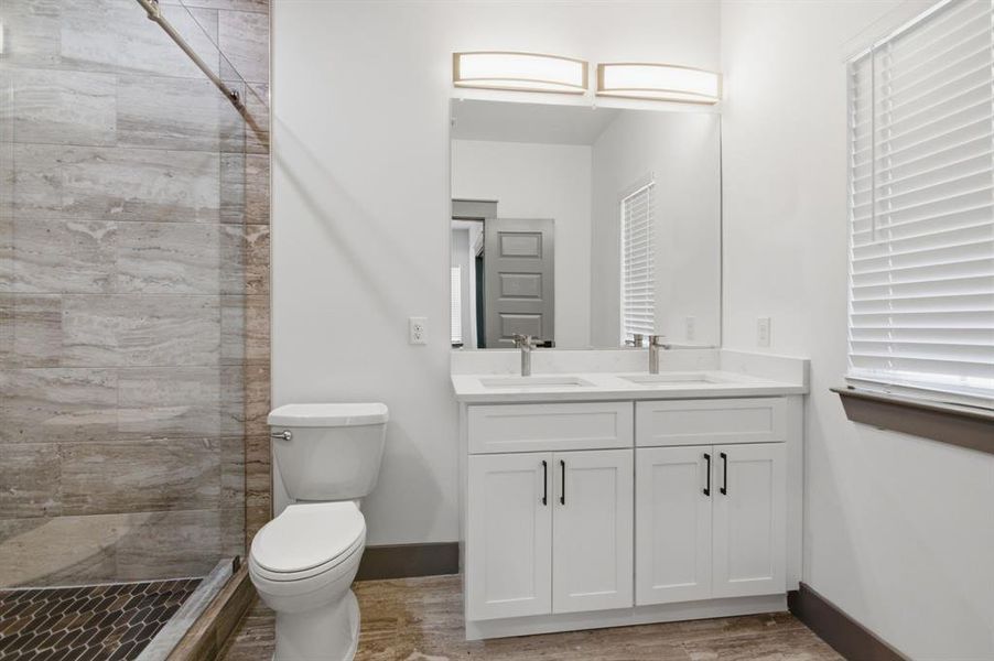 Contemporary bathroom featuring a double vanity with white cabinetry, dual undermount sinks, and polished chrome faucets
