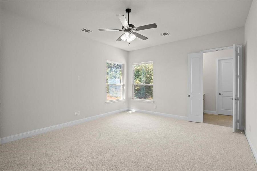 Carpeted spare room with ceiling fan