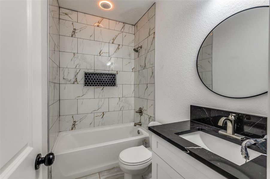 Bathroom with a textured wall, shower / tub combination, and vanity Bathroom with a textured wall, shower / tub combination, and vanity