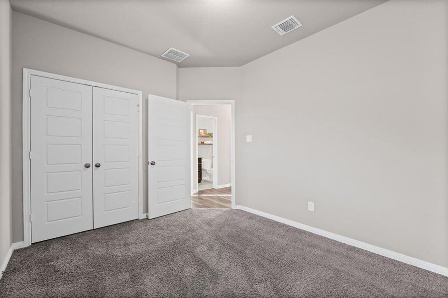 Unfurnished bedroom with carpet flooring and a closet Unfurnished bedroom with carpet flooring and a closet
