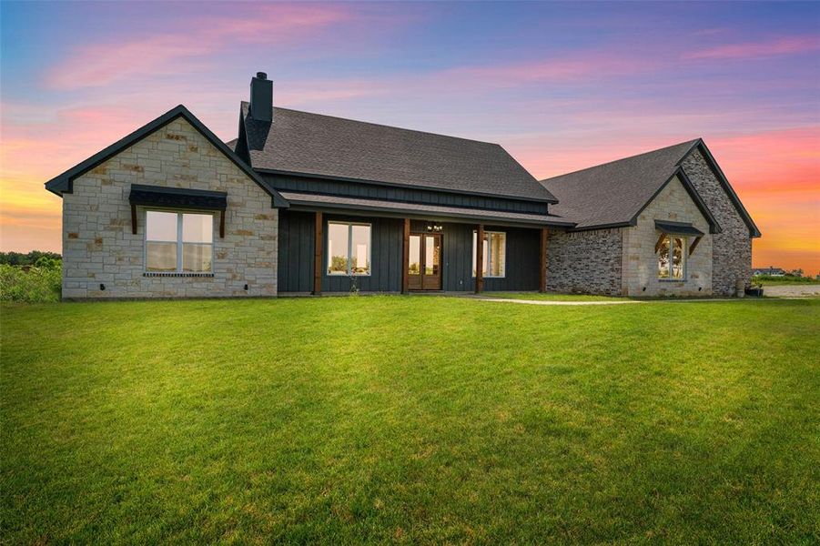Modern farmhouse exterior featuring stone and vertical panel siding