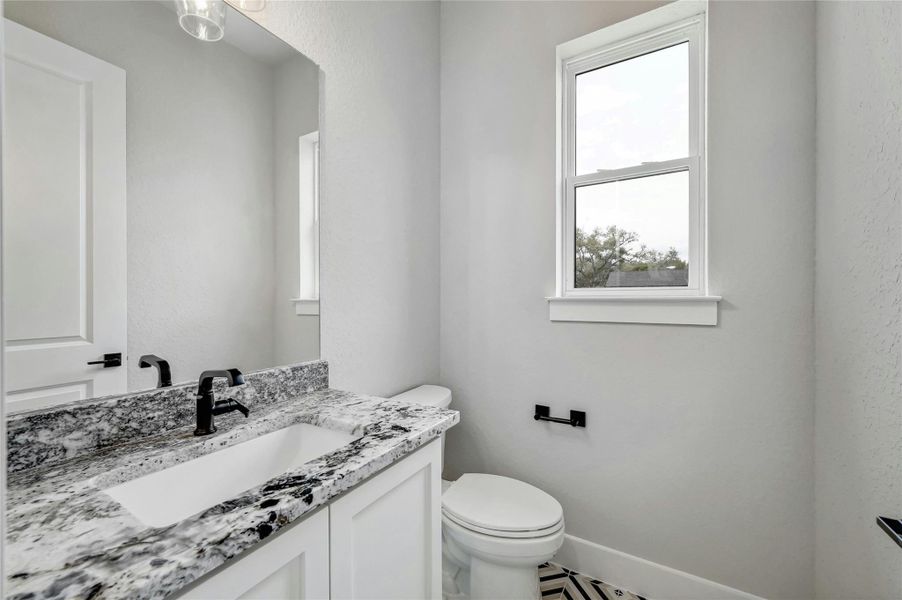 Half bathroom with toilet, a baseboard radiator, baseboards, and vanity