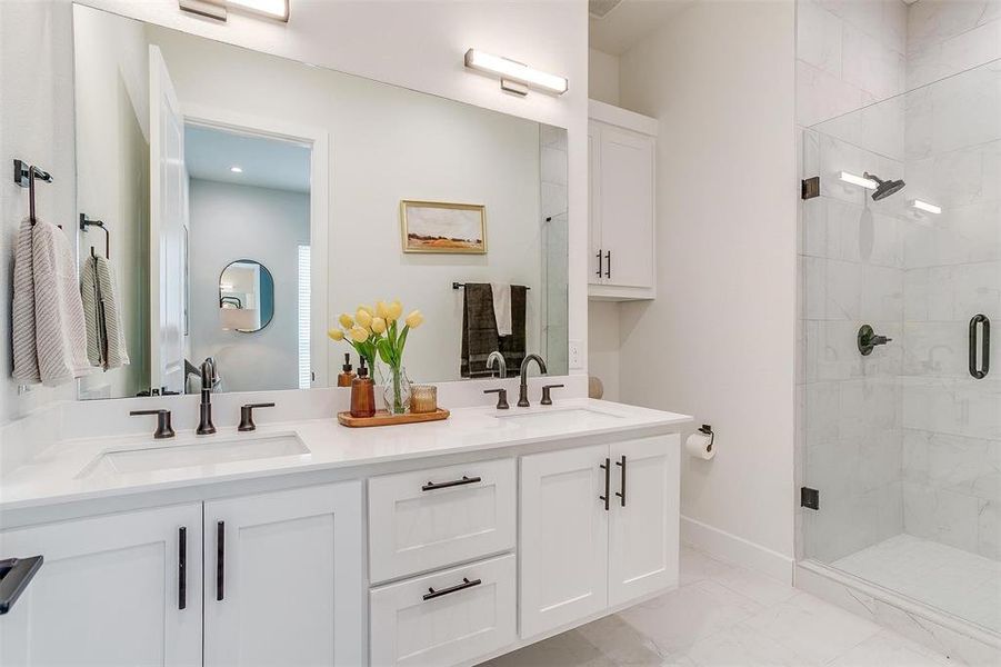 Indulge in the luxurious features of the primary bathroom, including quartz countertops, dual vanities with ample storage space, and Delta plumbing fixtures. This well-appointed space combines functionality with elegance, offering a spa-like experience right at home.