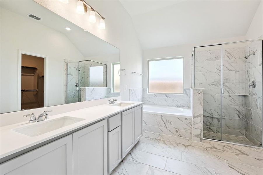 Bathroom with double vanity, tile patterned floors, separate shower and tub, and vaulted ceiling