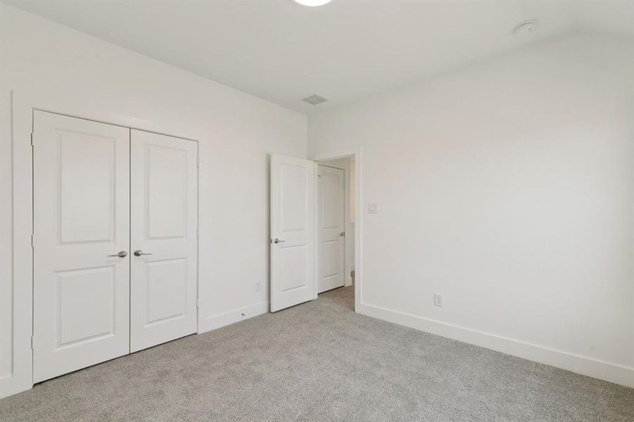Unfurnished bedroom with carpet and a closet Unfurnished bedroom with carpet and a closet