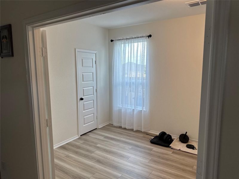 A versatile interior space featuring durable laminate flooring and a well-lit window.