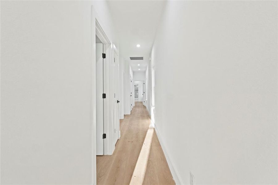 Corridor with light wood-style flooring and recessed lighting Corridor with light wood-style flooring and recessed lighting