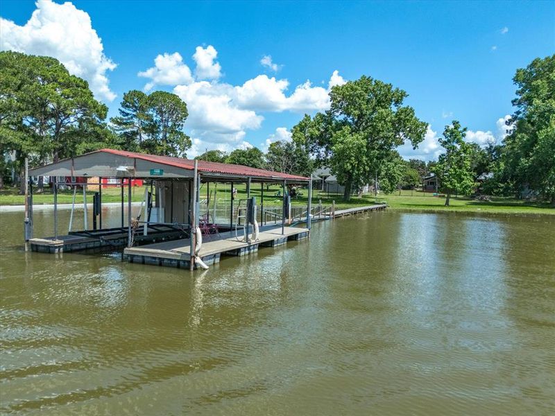 Dock area featuring boat lift and a water view Dock area featuring boat lift and a water view