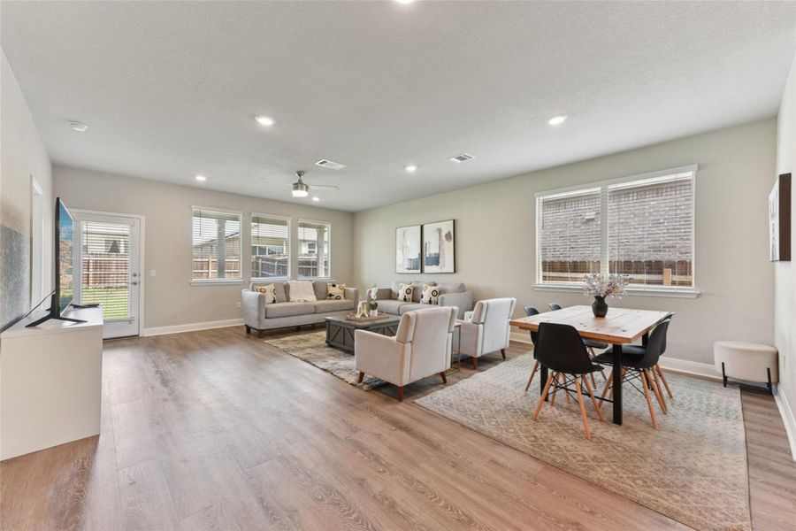 Living area featuring wood finished floors, ceiling fan, and recessed lighting Living area featuring wood finished floors, ceiling fan, and recessed lighting