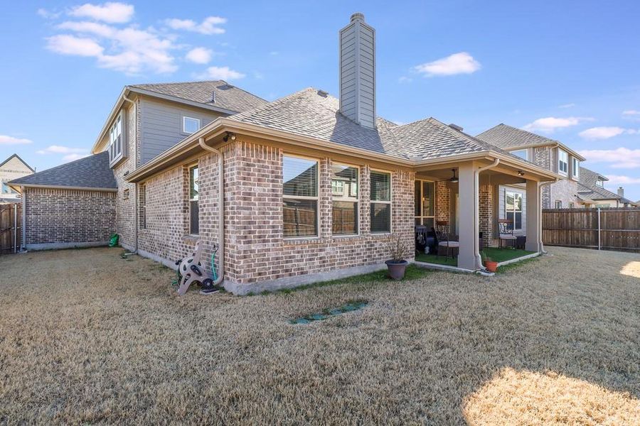 Rear view of property with a fenced backyard, a patio, brick siding, and a chimney Rear view of property with a fenced backyard, a patio, brick siding, and a chimney