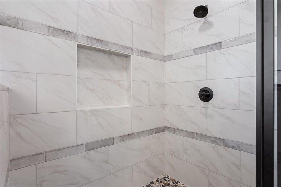 A pristine tiled shower with a built-in niche offers a refreshing retreat.