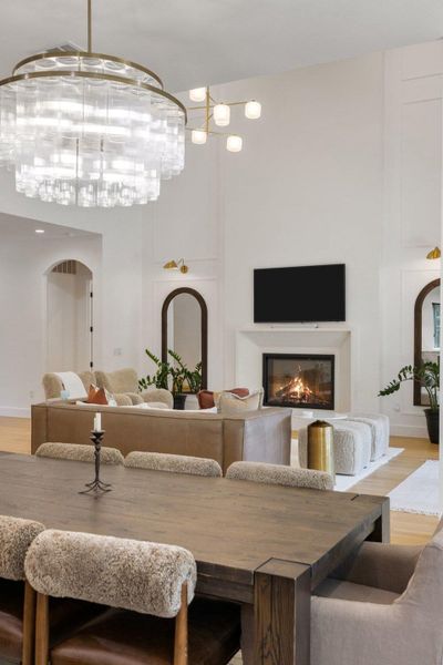 A grand, naturally illuminated living area showcases a captivating fireplace and high ceilings. A grand, naturally illuminated living area showcases a captivating fireplace and high ceilings.