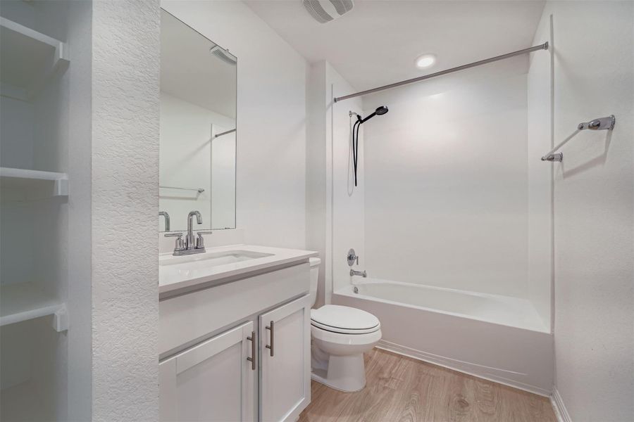 Full bathroom with vanity, tub / shower combination, and light wood-type flooring