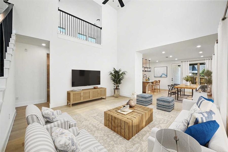 Living room featuring light wood finished floors, recessed lighting, a high ceiling, and ceiling fan Living room featuring light wood finished floors, recessed lighting, a high ceiling, and ceiling fan