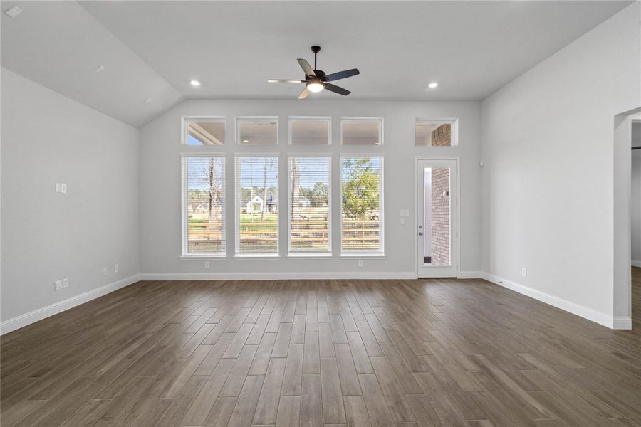 A grand great room with tall ceilings, ceiling fan, a wall of windows flooding this space with abundant natural light, and an open, inviting ambiance--perfect for gatherings, relaxation, and making memories. A grand great room with tall ceilings, ceiling fan, a wall of windows flooding this space with abundant natural light, and an open, inviting ambiance--perfect for gatherings, relaxation, and making memories.