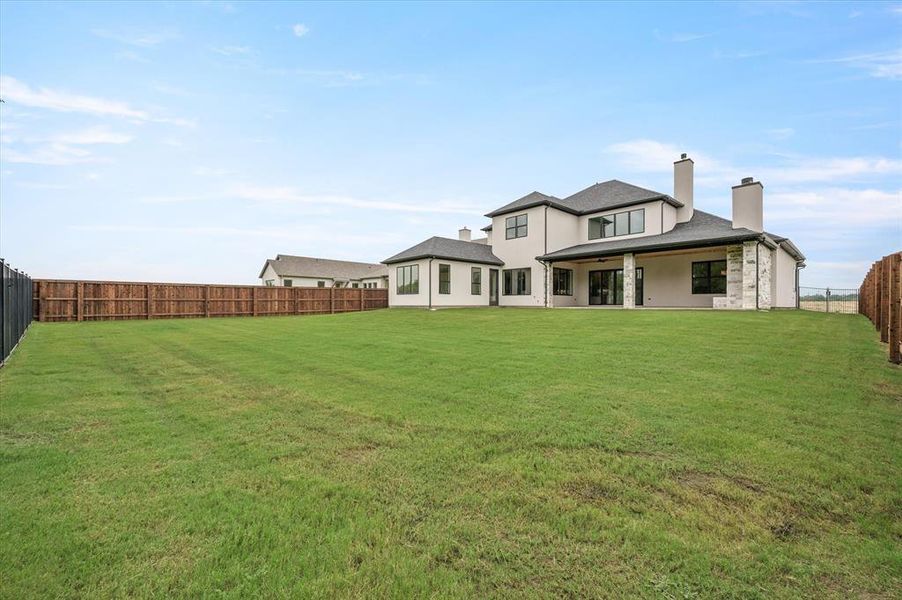 Rear view of house featuring a yard