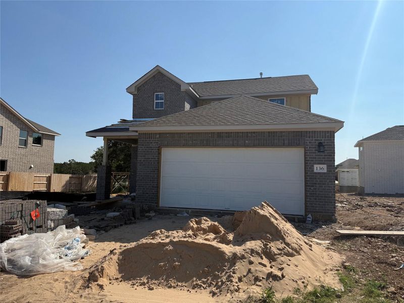 Front exterior of a new home in The Cottages at La Cima, San Marcos, TX, highlighting curb appeal (Image 1).