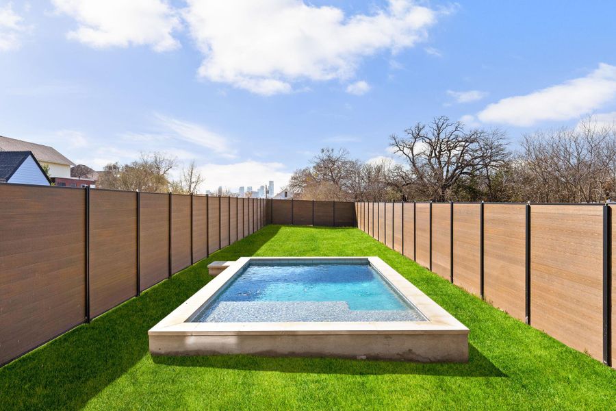 View of pool with a fenced backyard and patio surround