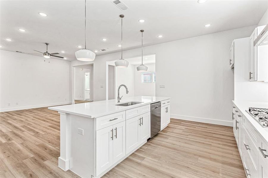 Kitchen featuring white cabinets, recessed lighting, light wood-style floors, a kitchen island with sink, and a ceiling fan