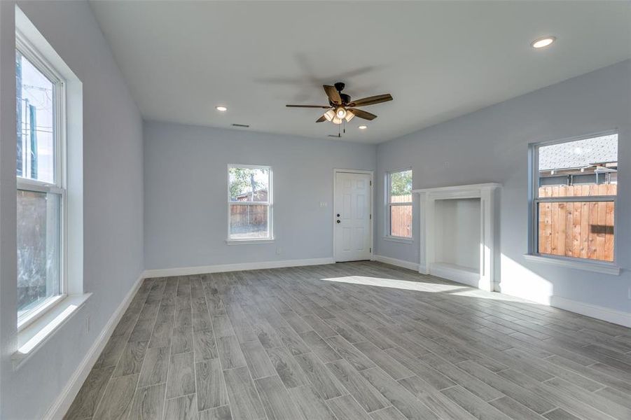 Unfurnished living room featuring ceiling fan and light hardwood / wood-style flooring