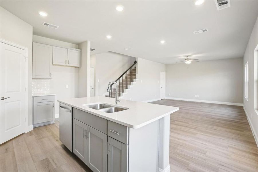 Kitchen featuring recessed lighting, light wood finished floors, tasteful backsplash, an island with sink, and dishwasher Kitchen featuring recessed lighting, light wood finished floors, tasteful backsplash, an island with sink, and dishwasher