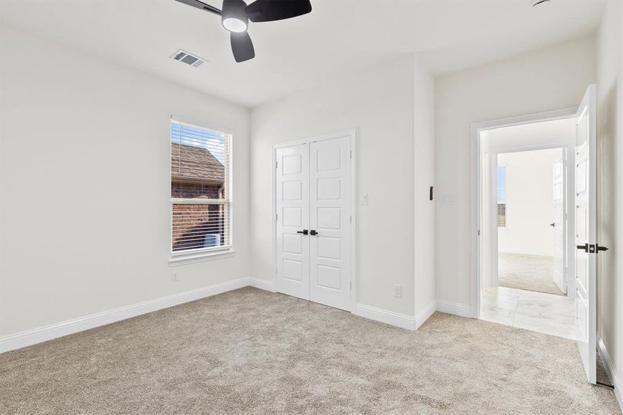 Unfurnished bedroom featuring baseboards, visible vents, light colored carpet, ceiling fan, and a closet Unfurnished bedroom featuring baseboards, visible vents, light colored carpet, ceiling fan, and a closet