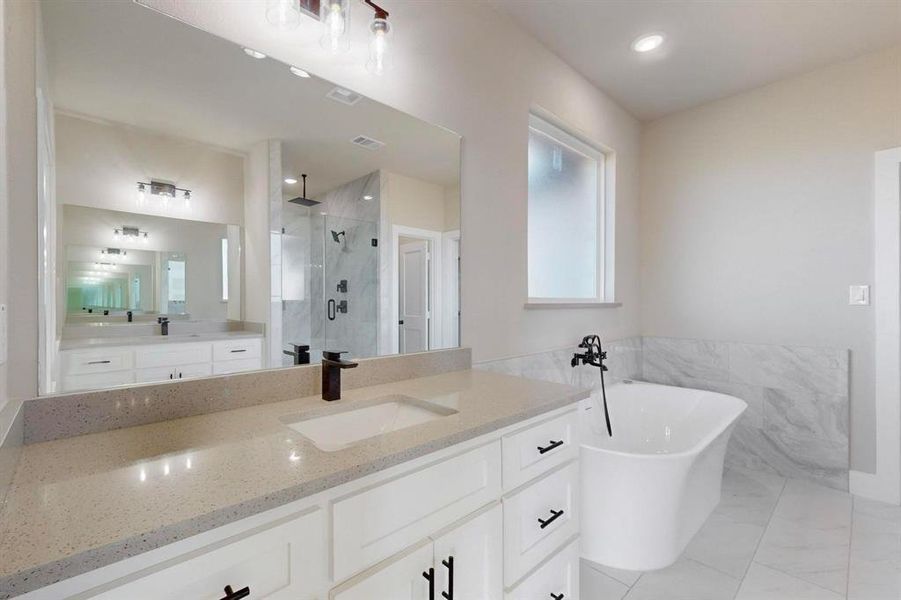 Bathroom featuring a shower stall, recessed lighting, a soaking tub, marble finish floor, and vanity