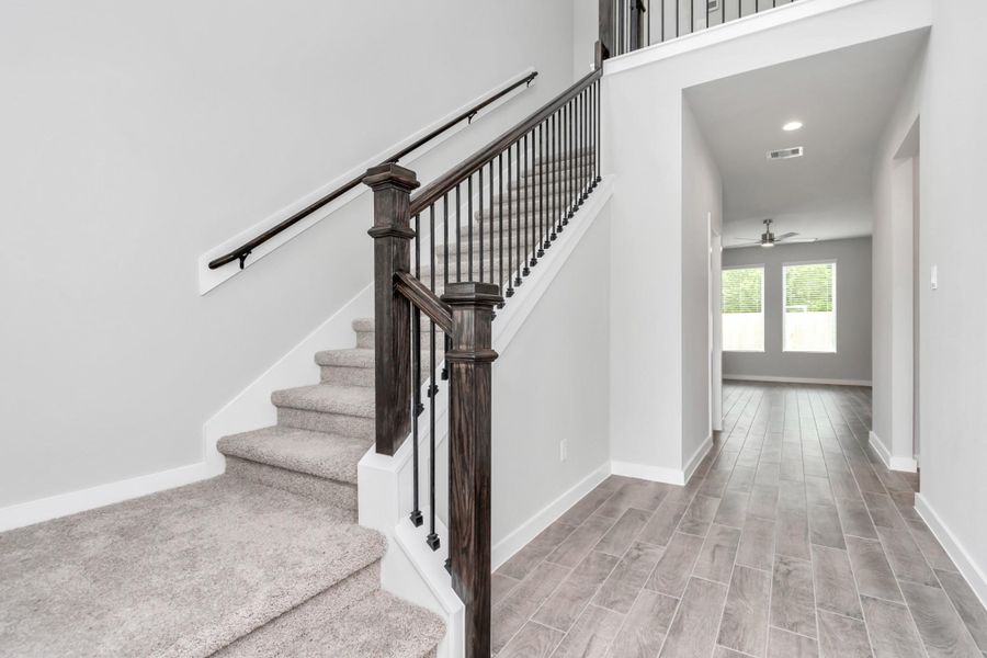 The majestic entryway allures with its high ceilings, embellished with sophisticated wood-look tile flooring and sleek oversized baseboards. Sample photo of completed home with similar floor plan. Actual colors and selections may vary. The majestic entryway allures with its high ceilings, embellished with sophisticated wood-look tile flooring and sleek oversized baseboards. Sample photo of completed home with similar floor plan. Actual colors and selections may vary.