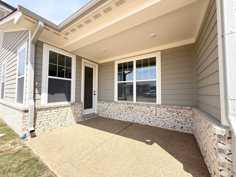 Property entrance featuring a patio and stone siding