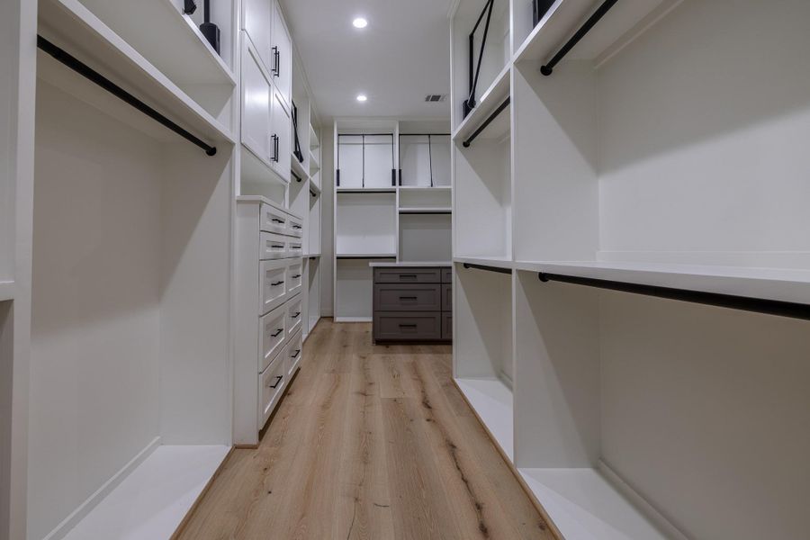 Oversized custom walk-in closet with built-ins and exceptional storage capacity.
