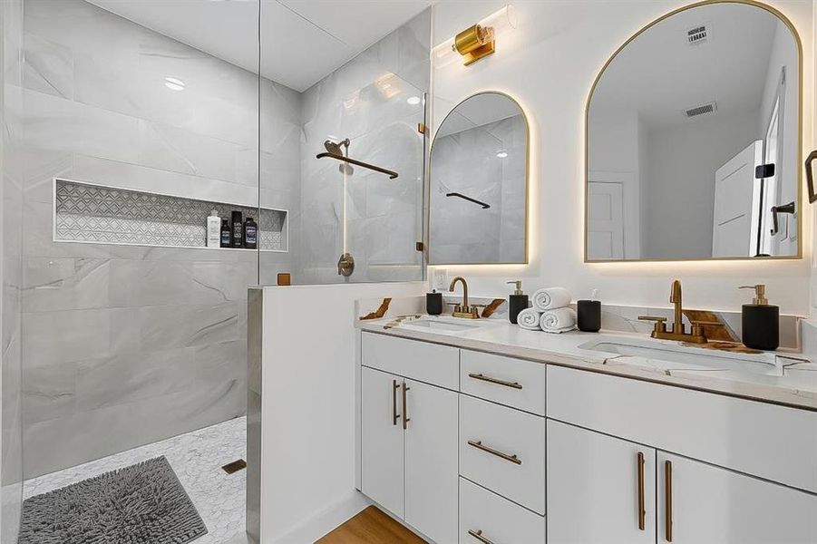 Bathroom featuring a walk in shower and double vanity Bathroom featuring a walk in shower and double vanity