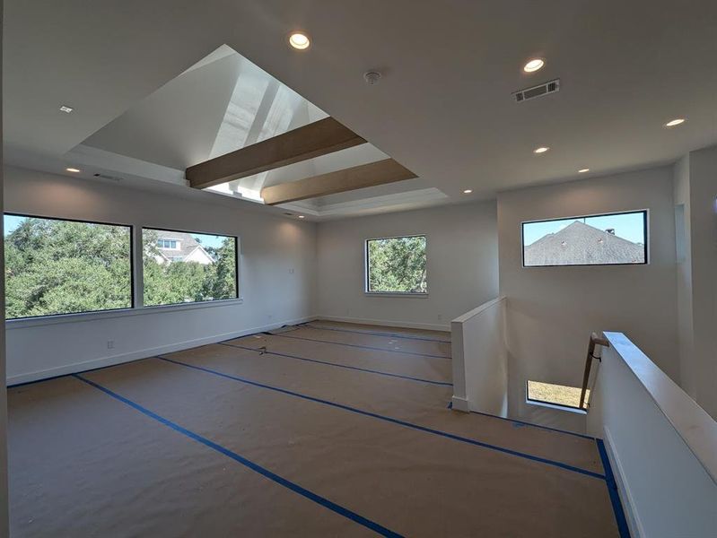 Media/Game Room with luminous vaulted ceiling with skylight and stained beams.