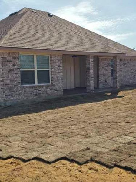 Back of property with brick siding, a patio area, and roof with shingles Back of property with brick siding, a patio area, and roof with shingles