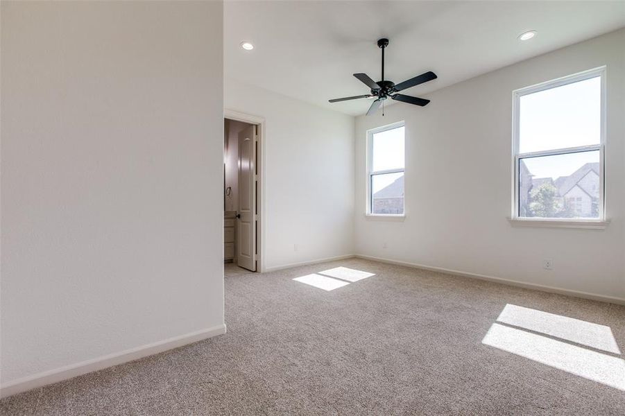 Carpeted spare room featuring ceiling fan