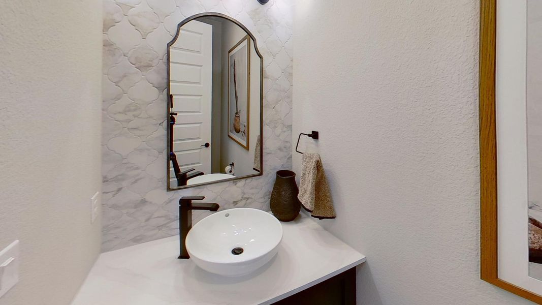 Bathroom featuring a textured wall and vanity