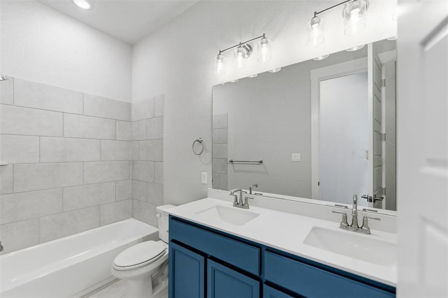 Full bath with double vanity, washtub / shower combination, and recessed lighting