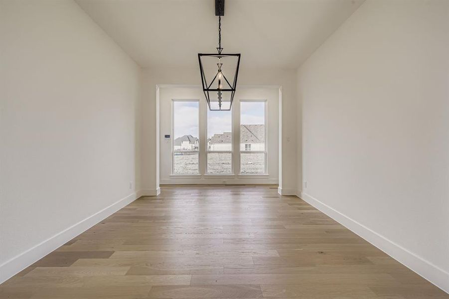 Unfurnished dining area with light wood-style floors and baseboards
