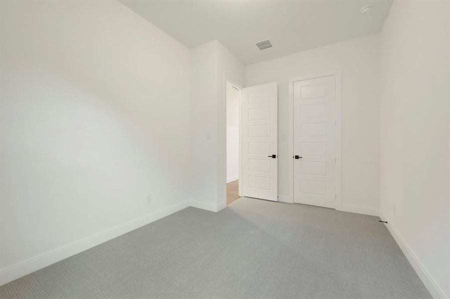 Unfurnished bedroom with carpet and a closet Unfurnished bedroom with carpet and a closet