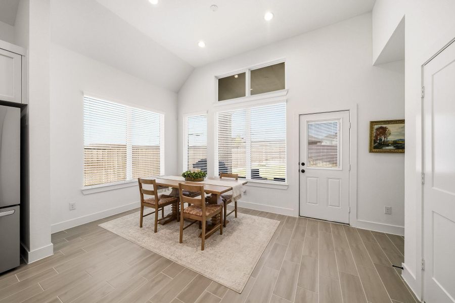 Windows with blinds frame views of the covered patio, while a patio door with integrated internal blinds opens to an inviting outdoor retreat, creating a refined, seamless transition between sophisticated indoor living and relaxed alfresco entertaining.