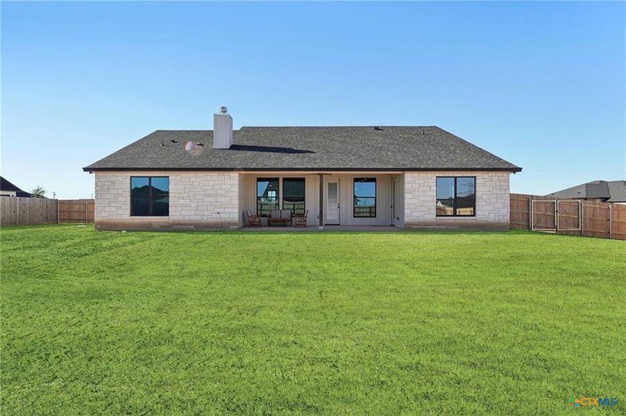 A spacious backyard with vibrant green grass offers ample room for outdoor activities. A spacious backyard with vibrant green grass offers ample room for outdoor activities.
