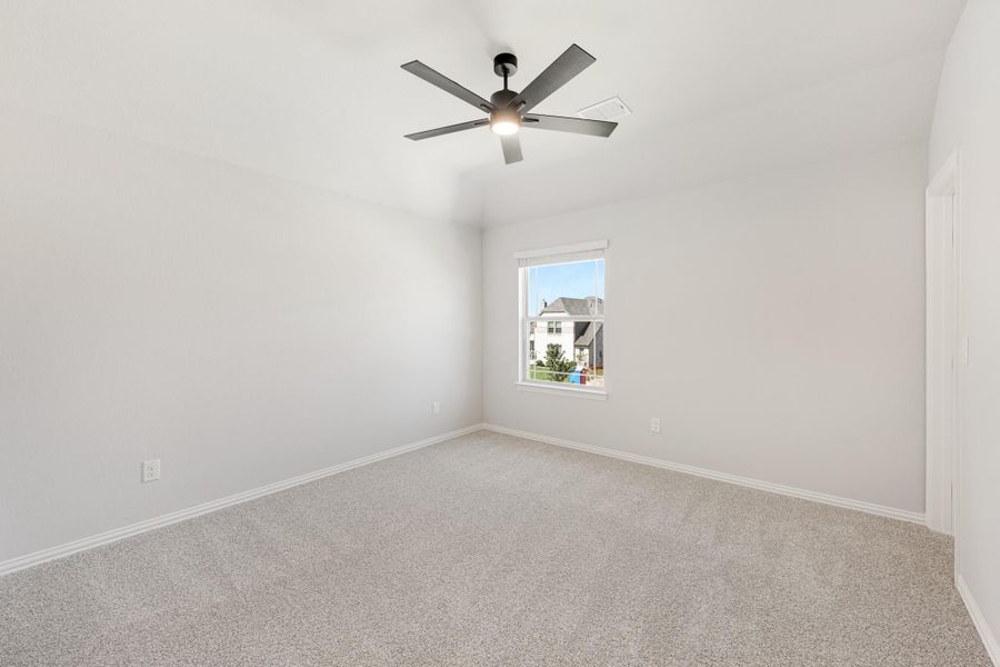 Empty bedroom with carpet flooring, ceiling fan with light, and a single window with neighborhood view Empty bedroom with carpet flooring, ceiling fan with light, and a single window with neighborhood view