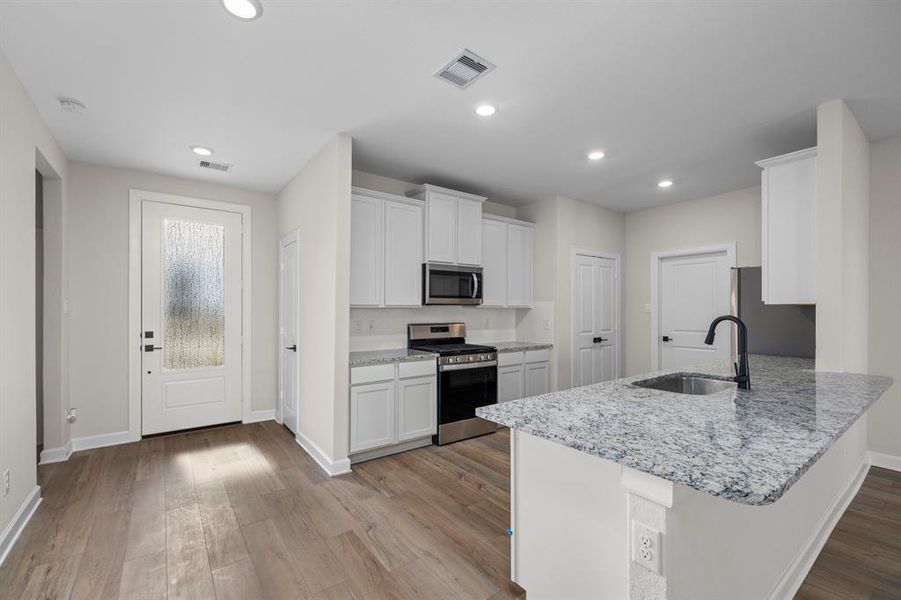 Welcome home! As you enter the home you will flow into the beautiful and modern kitchen featuring sleek granite countertops, stainless steel appliances, and a spacious island. The open layout and natural light create a welcoming and functional space, perfect for cooking and entertaining.