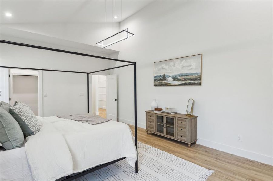 Bedroom featuring light hardwood / wood-style flooring, a closet, and vaulted ceiling