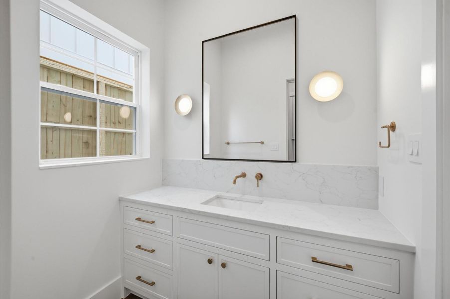 Powder bath vanity with access to toilet and shower area.