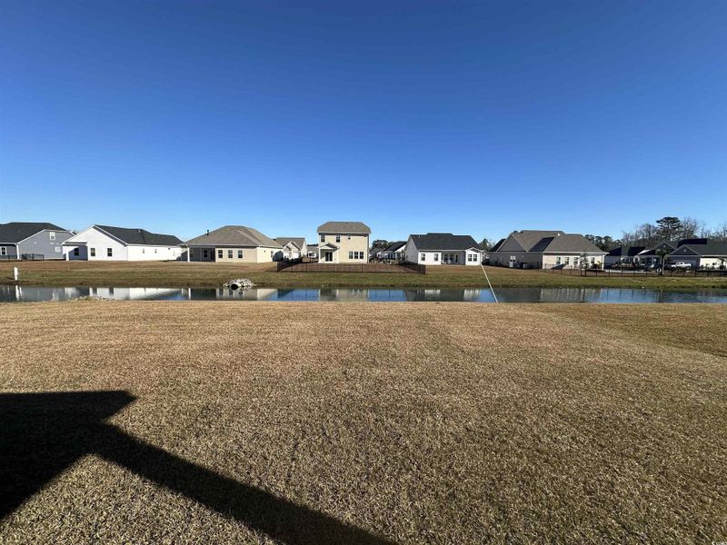View of grassy yard with a residential view and a water view