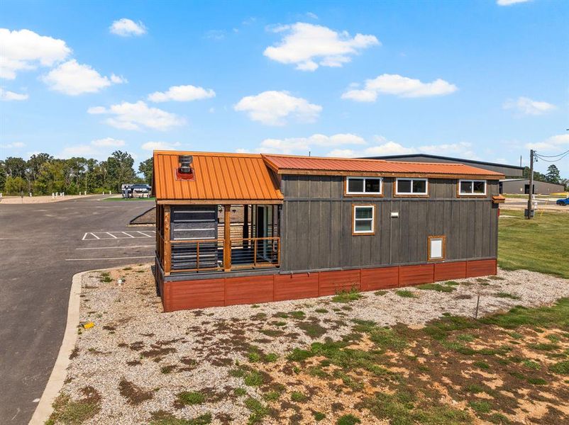 View of home's exterior featuring a metal roof and uncovered parking